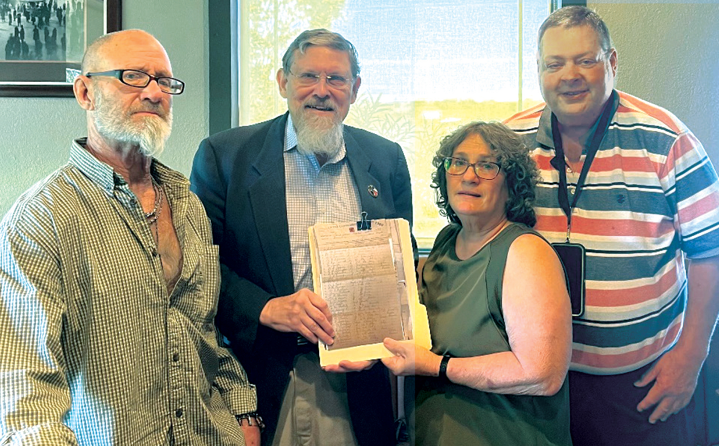 On behalf of the Ennis Public Library, Lisa Slaughter accepts the gift of copies of early records of the Ennis United Confederate Veterans from members of the William Henry Parsons Camp #415, Sons of Confederate Veterans.  From left, Jimmy Neil Crawford, Rob Jones, Lisa Slaughter, and Randy Cox. Submitted photo.