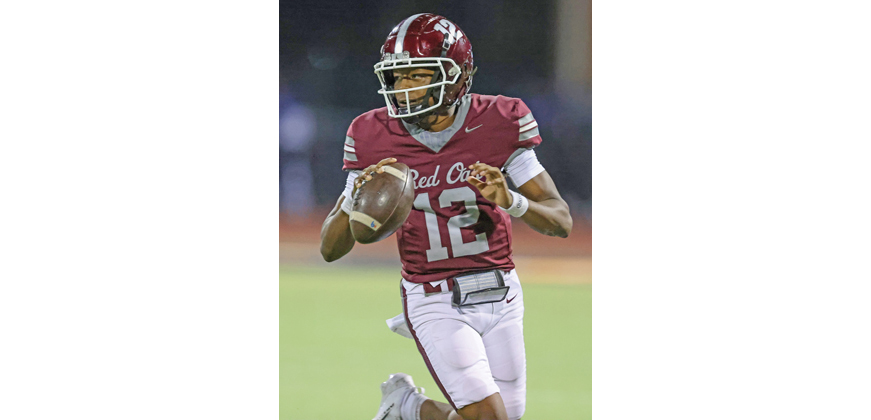 The Hawks senior quarterback Tuhran Square II (12) looks downfield while running towards the sideline. Photo by Steve Patterson / Moving Pictures