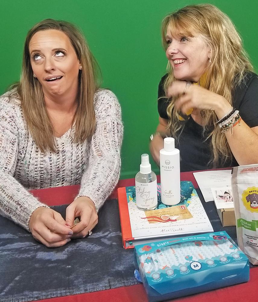 “Pretty Girls Review” with Amber Hall and Rita Cook in front of green screen.