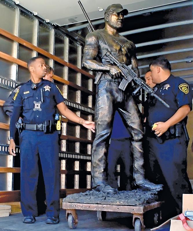 Members of law enforcement escorted the 1,000 pound statue of Chris Kyle and prepare to unload it at the Waxahachie Civic Center Thursday morning after moving it from Rockwall.