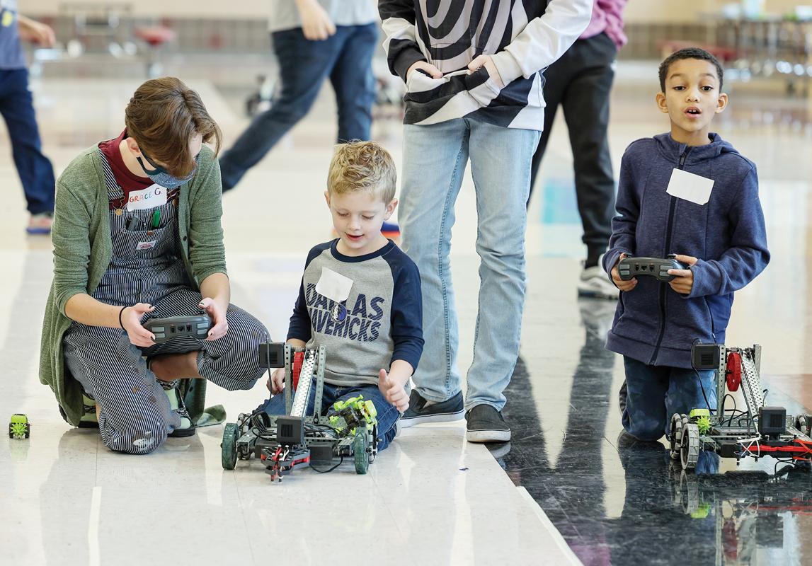 With assistance from Robotic Club members, kids were able to operate a robot through a course marked on the floor and use a mechanical arm and claw to grab and lift a block of wood.