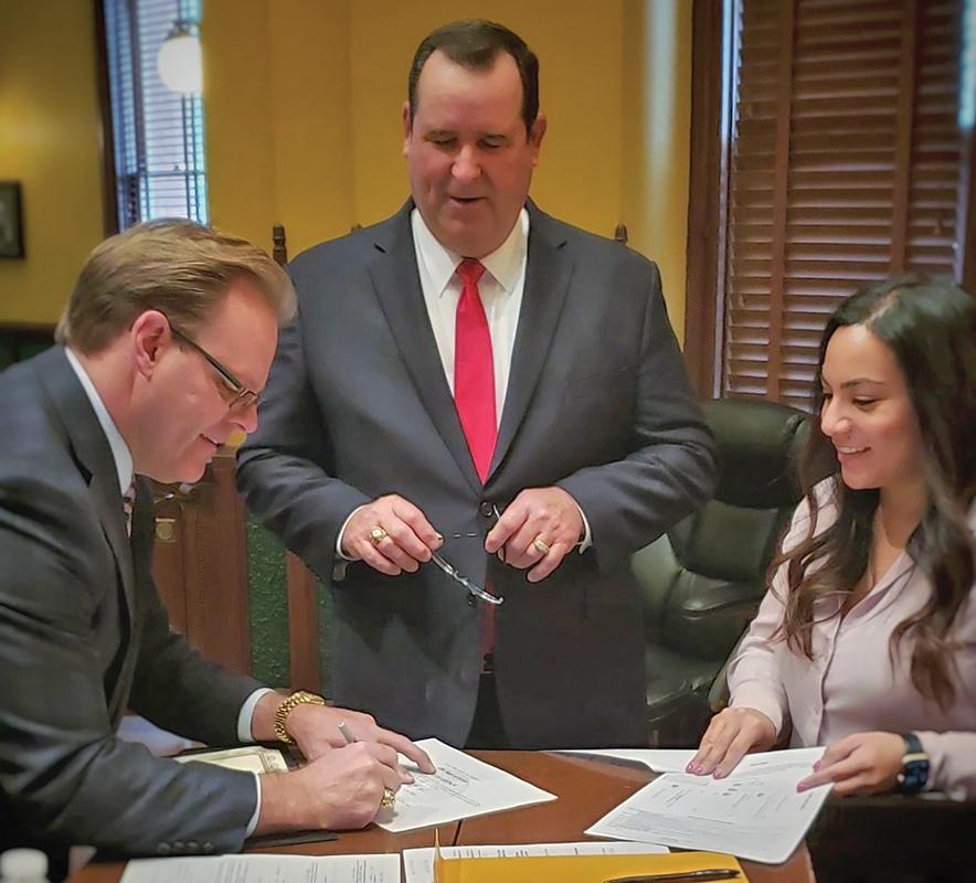 Ellis County Judge Todd Little signs new tax assessor Richard Rozier’s oath of office.