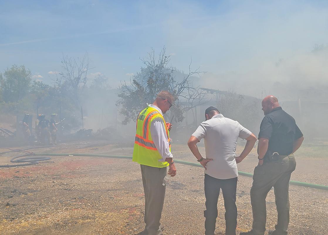 Ferris City Manager Brooks Williams (left) receives an update on fire situations.