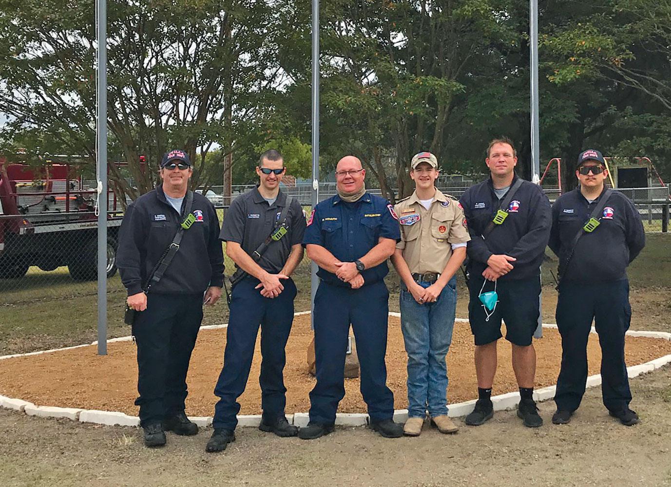 Following the flag ceremony, members of Ovilla’s first responders pose in front of the new flagpoles. Pictured are K. Mooney, firefighter/paramedic; T. Burnett, firefighter; E. Homuth, battalion chief; Tyler Homuth, boy scout; P. Hobin, firefighter/paramedic; and J. Schepps, firefighter.