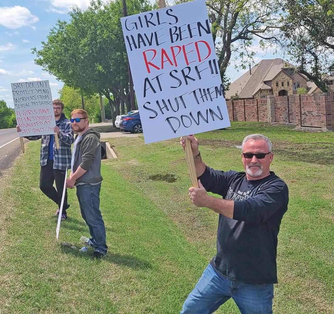 Gary Brignon and sons hold up signs at Scarborough Faire asking for it to be shut down due to the alleged sexual assaults taking place there.