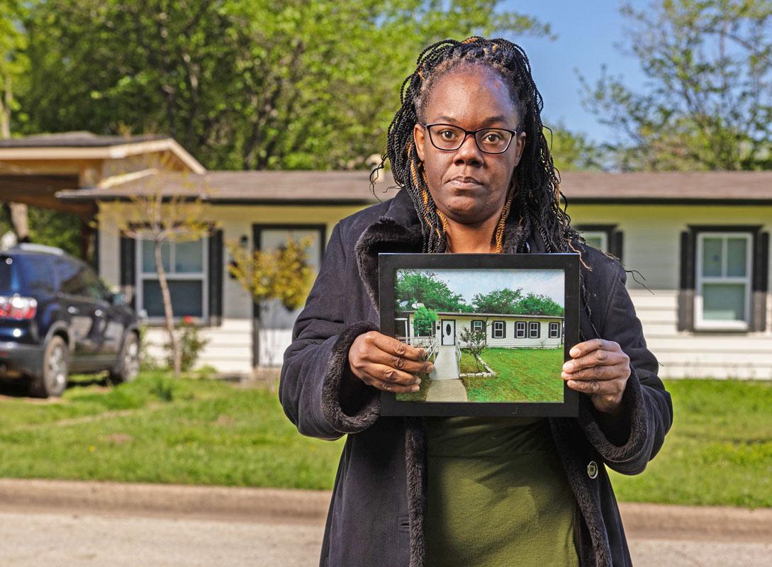 Karen Jimerson holding a photo of her house which was raided (note the wheelchair ramp), standing in front of the actual target house. Photo courtesy Institute for Justice.