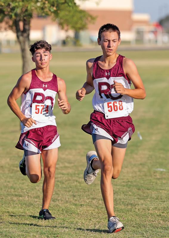 Two members of the Red Oak High School boys Cross Country Team pass the 1-mile marker during the Life School Stampede at the Waxahachie Sports Complex.