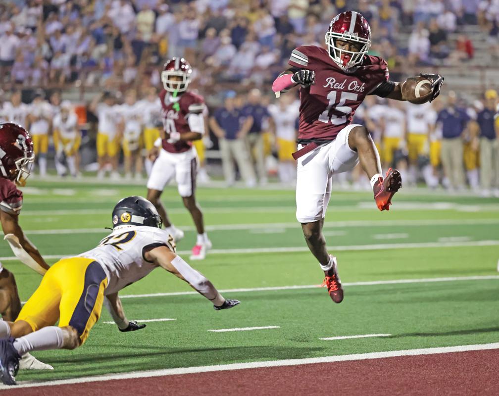 Running back Kingston McAdams (15) leaps over a diving defender for a Hawk’s touchdown against Highland Park. Photo by Steve Patterson / Moving Pictures.