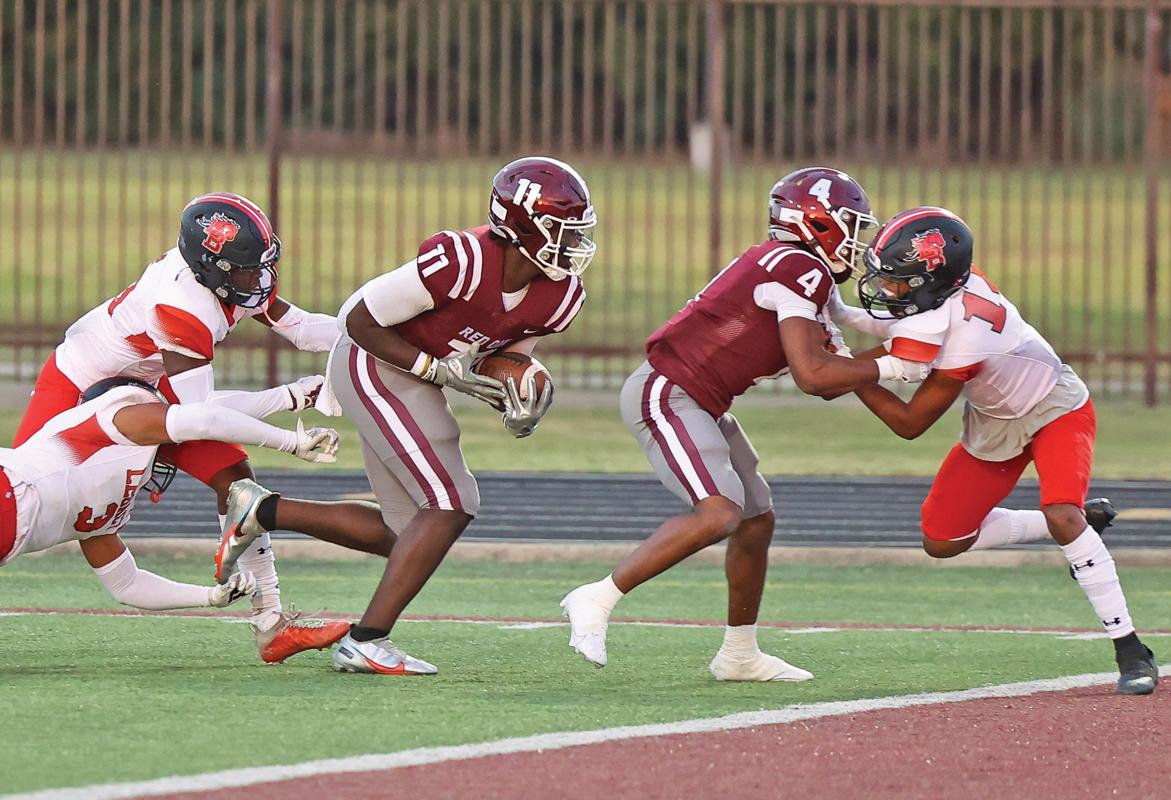 Photo by Steve Patterson / Moving Pictures WR La’Kelsey Johnson, Jr. (11) runs over two Broncos and gets a little help from fellow WR Warren Roberson (4) to score another Hawks touchdown.
