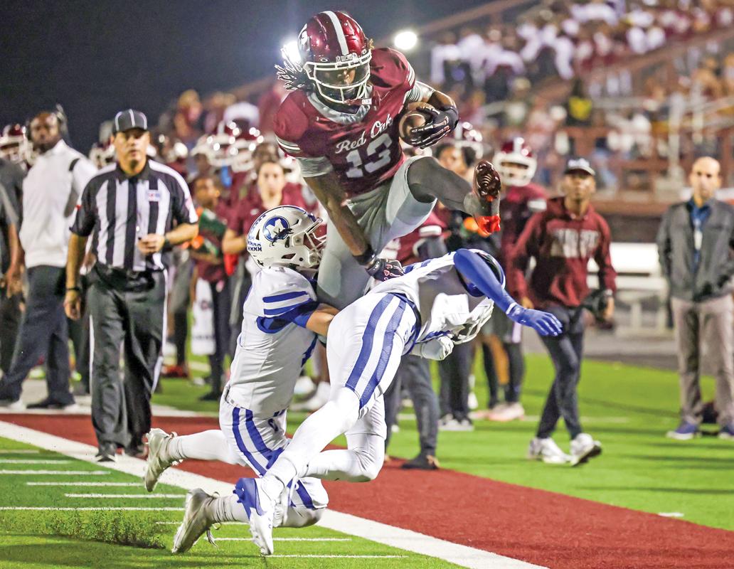Jacque Overton (13) leaps over two Panther defenders finally coming down inside the 5-yard line, setting up another Hawk’s score. Photo by Steve Patterson / Moving Pictures.