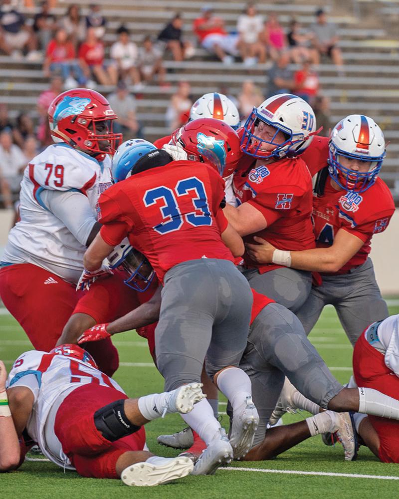 Heritage defense’s #33 Noah Gray (33), Scott Ellis (30) and Ben Eskins (94) stuffed a run play. Photo by Kirk Holt.