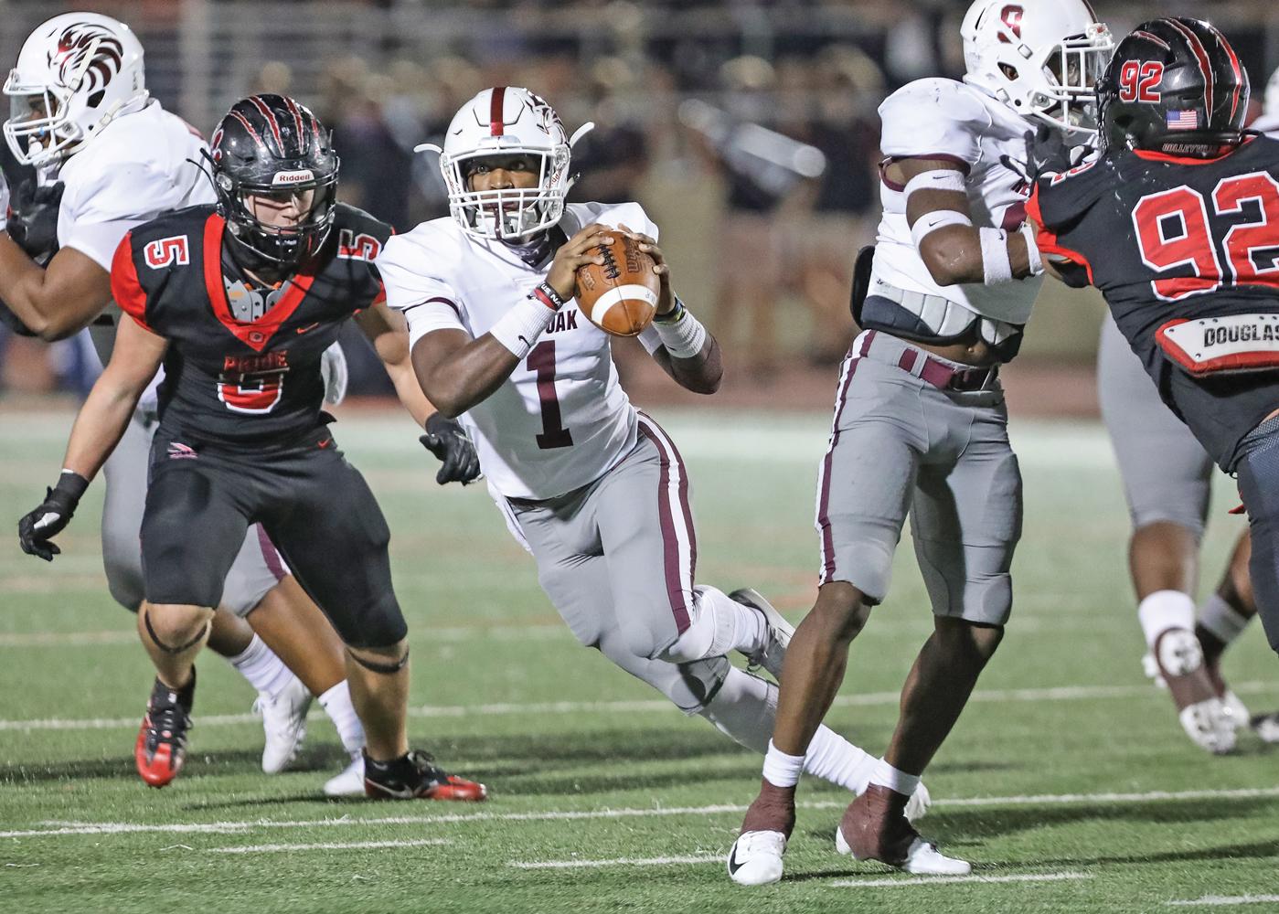 QB Chris Parson (1) scrambles out of the pocket looking downfield for an open receiver. Photo by Steve Patterson / Moving Pictures.