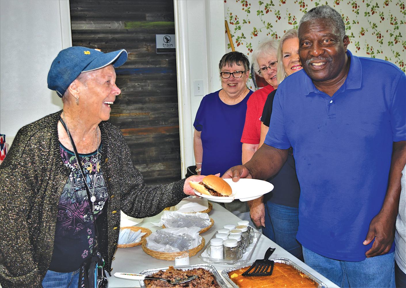 Councilman Tommy Scott serves BBQ at the Ferris Senior Center Wednesday, May 29.