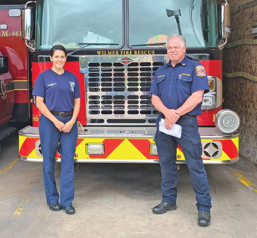 Maria Gabriela Gillen and Wilmer Fire Chief Mark Hamilton are shown after the city hired its first female fire fighter.