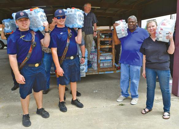 Following three days of no water on the east side of Interstate 45 in Ferris, Councilwoman Sherie Chapman (right) took action and obtained bottled water for the residents. Helping is Fire Captain Clayton Haughey, Firefighter Garrett Wright and Councilman Tommy Scott.
