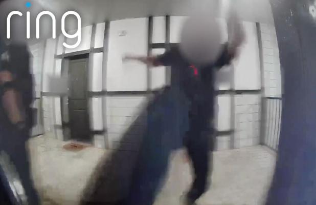 The image shows a Red Oak Police Officer trying to kick in the door. Photo courtesy NBC 5 Dallas-Fort Worth.
