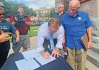 Ellis County Judge Todd Little signs the proclamation declaring “Open Texas” in front of the Ellis County Courthouse.